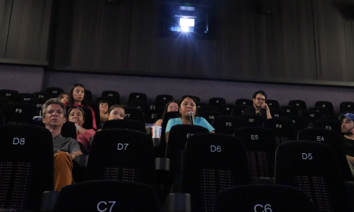 Mujer con micrófono en la proyección de Isleño.